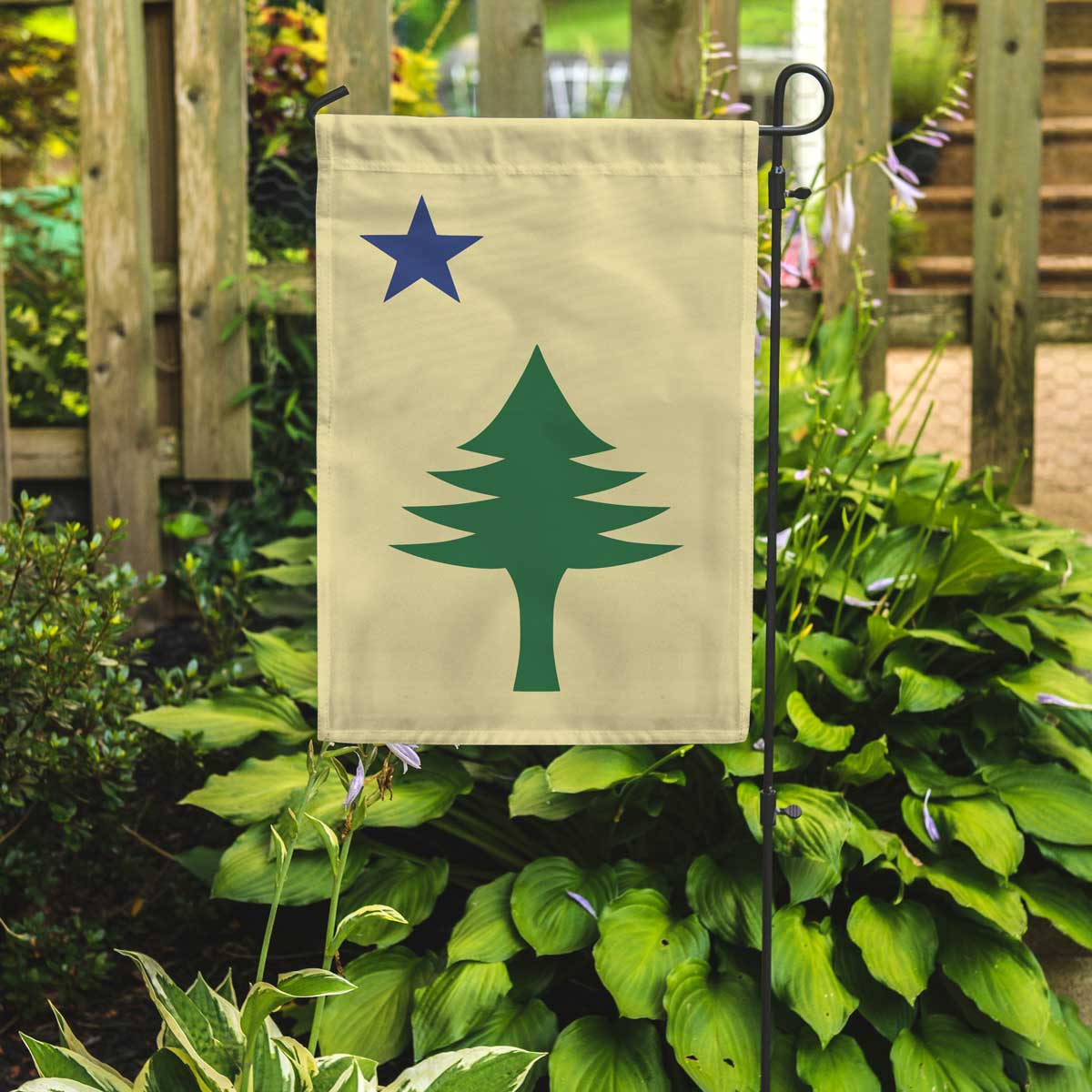 Maine 1901 garden flag with maritime tree produced by flags for good in a garden setting