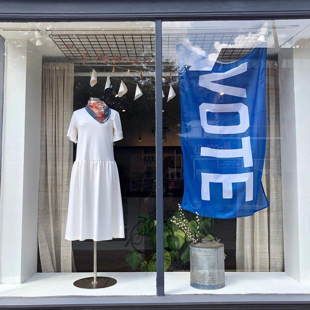 Vote Flag hanging in a store window next to a manaquin