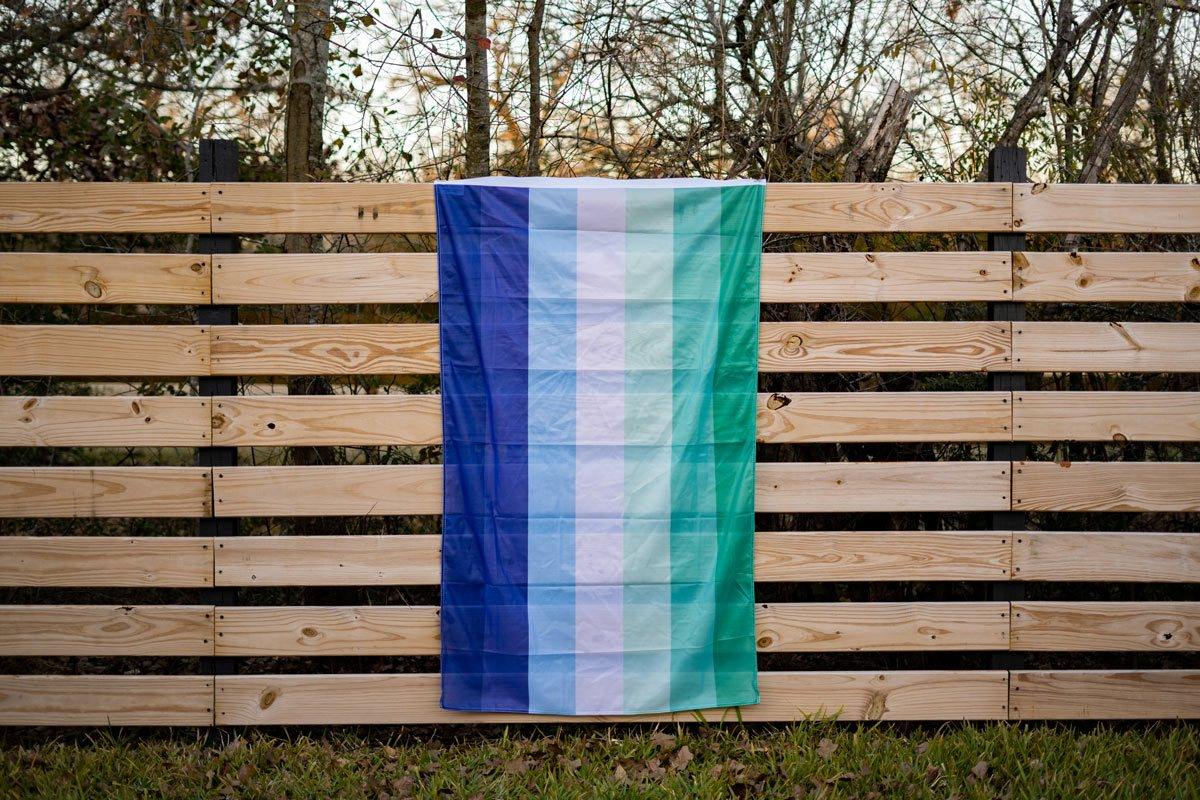 man loving man (MLM) gay pride flag on a fence