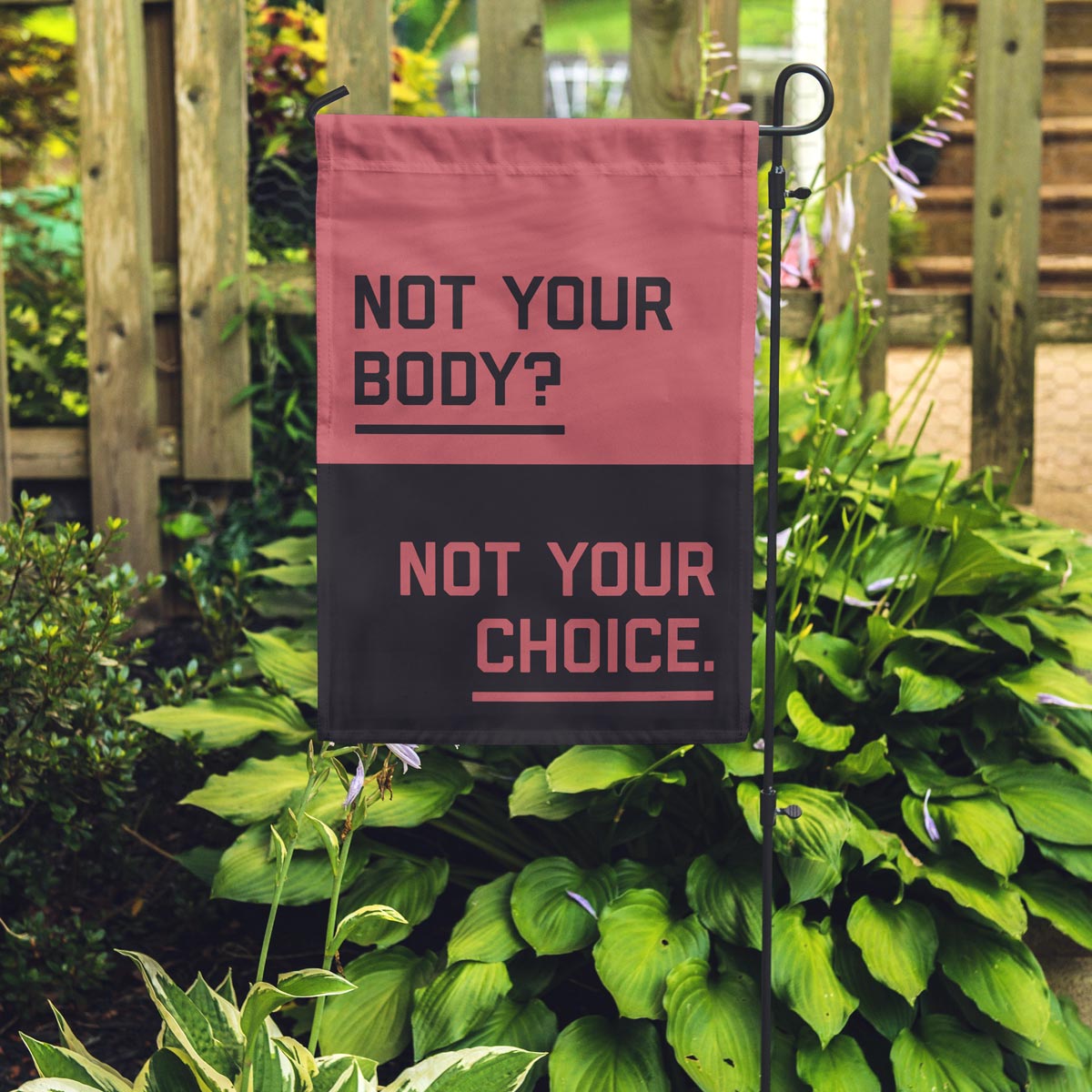 &quot;Not your body? Not your choice.&quot; garden flag placed in a garden