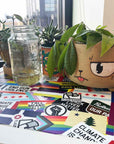 Flags For Good Stickers on a surface with potted plants