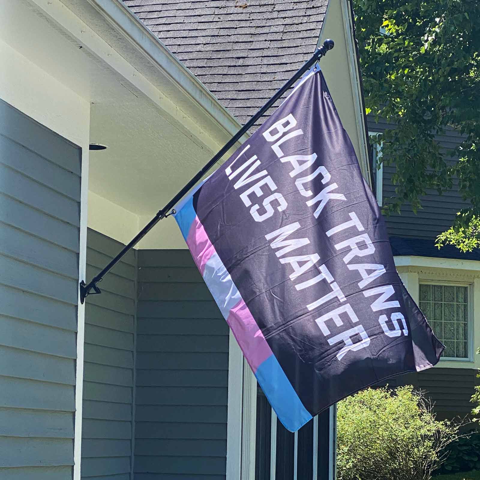 Black Trans Lives Matter Flag flying in front of a house