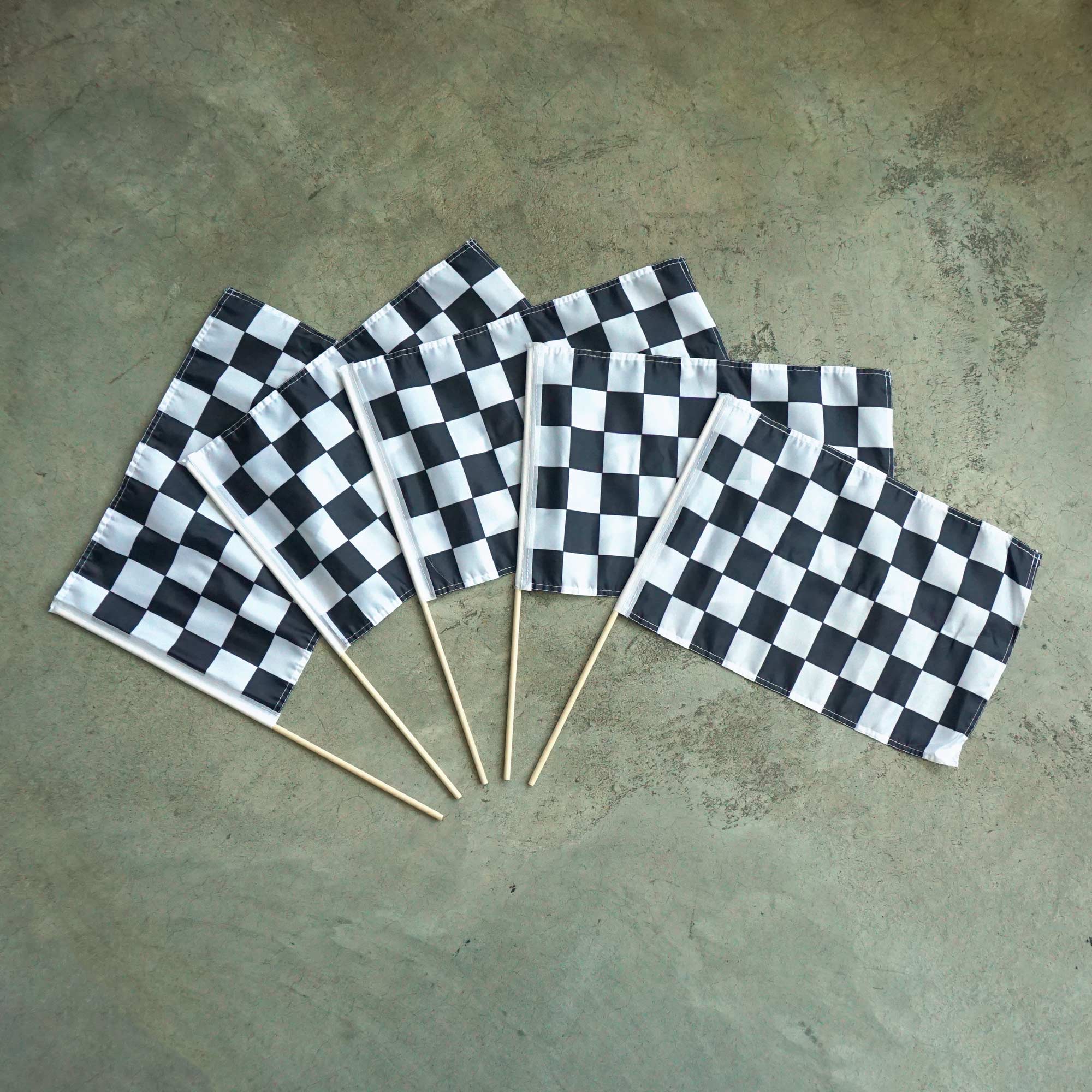 Set of checkered flags on sticks on a concrete surface