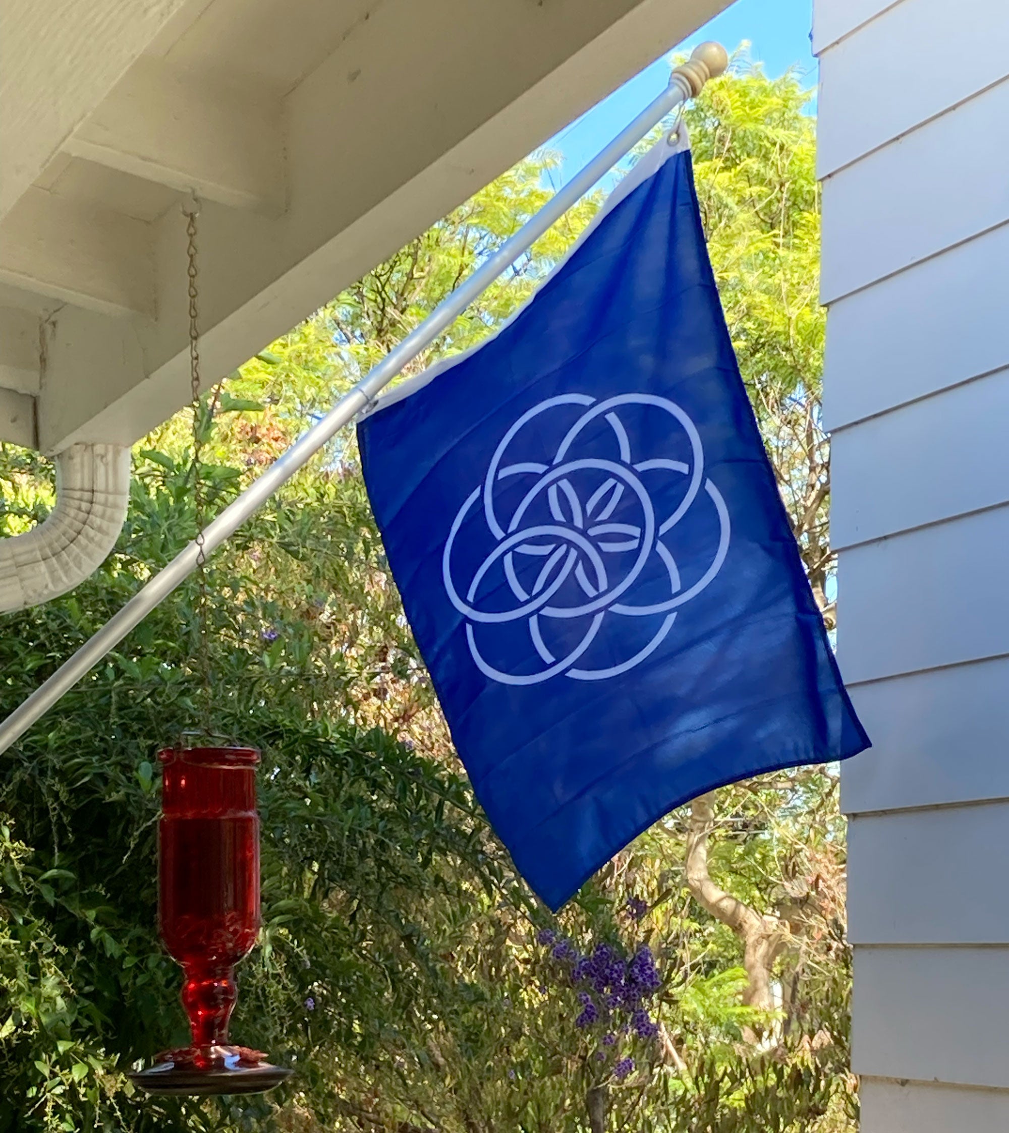 International Flag of Planet Earth on a flag pole in front of a home