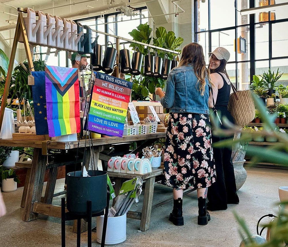 women shopping in a garden store with flags for good garden flags displayed in front of them