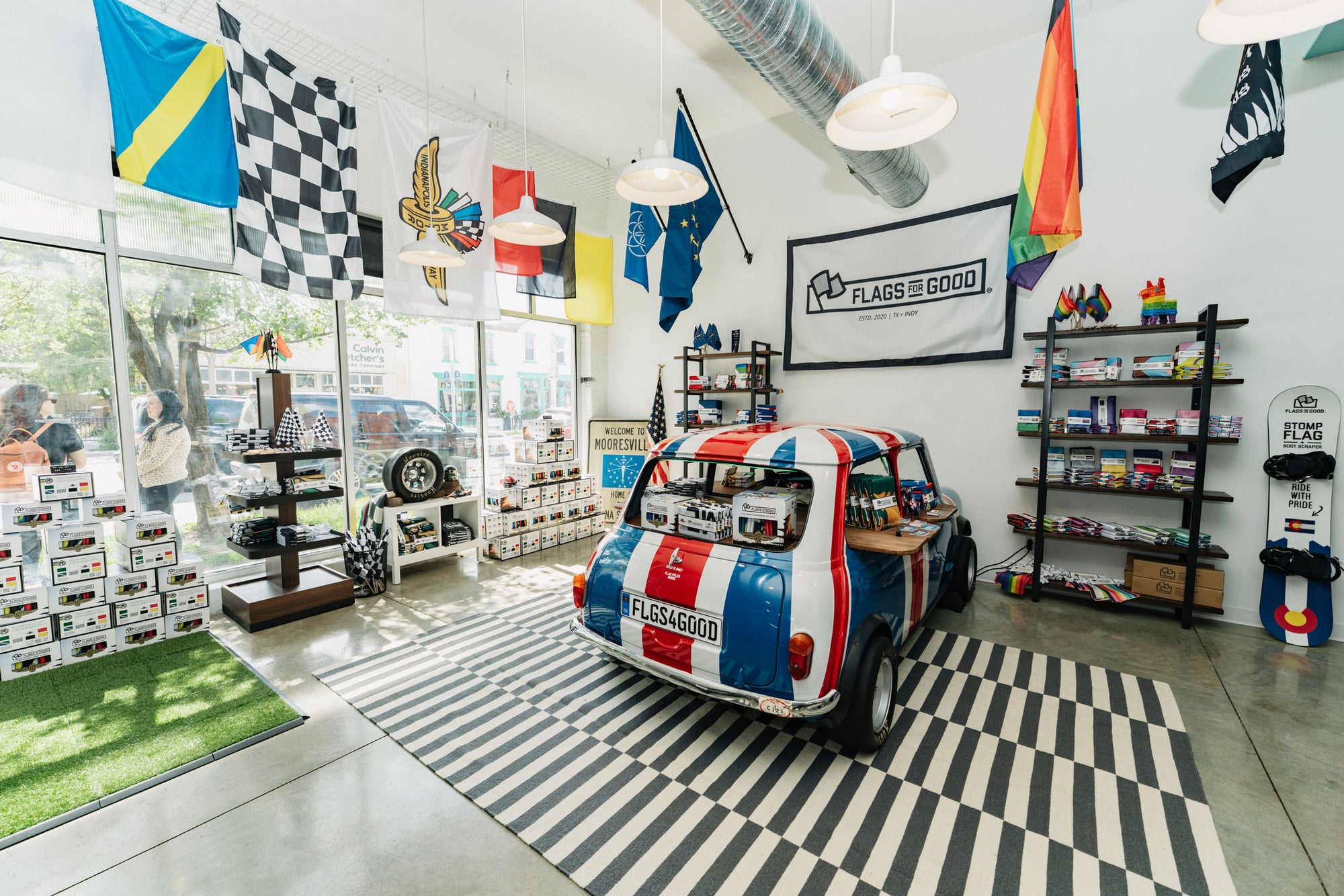 Decorative car with British flag design in a store setting with various flags and shelves.