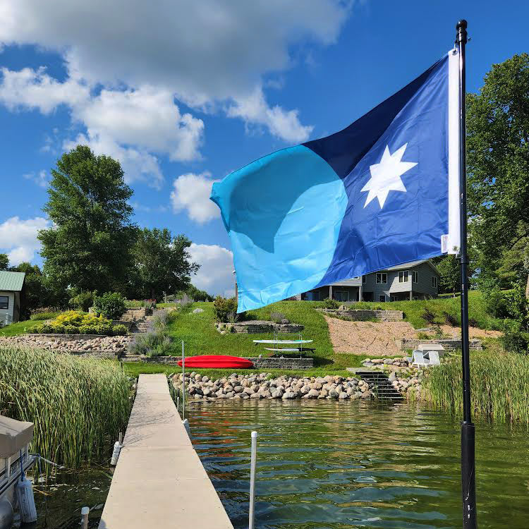 New Updated Minnesota State Flag flying on a flag pole on a dock.