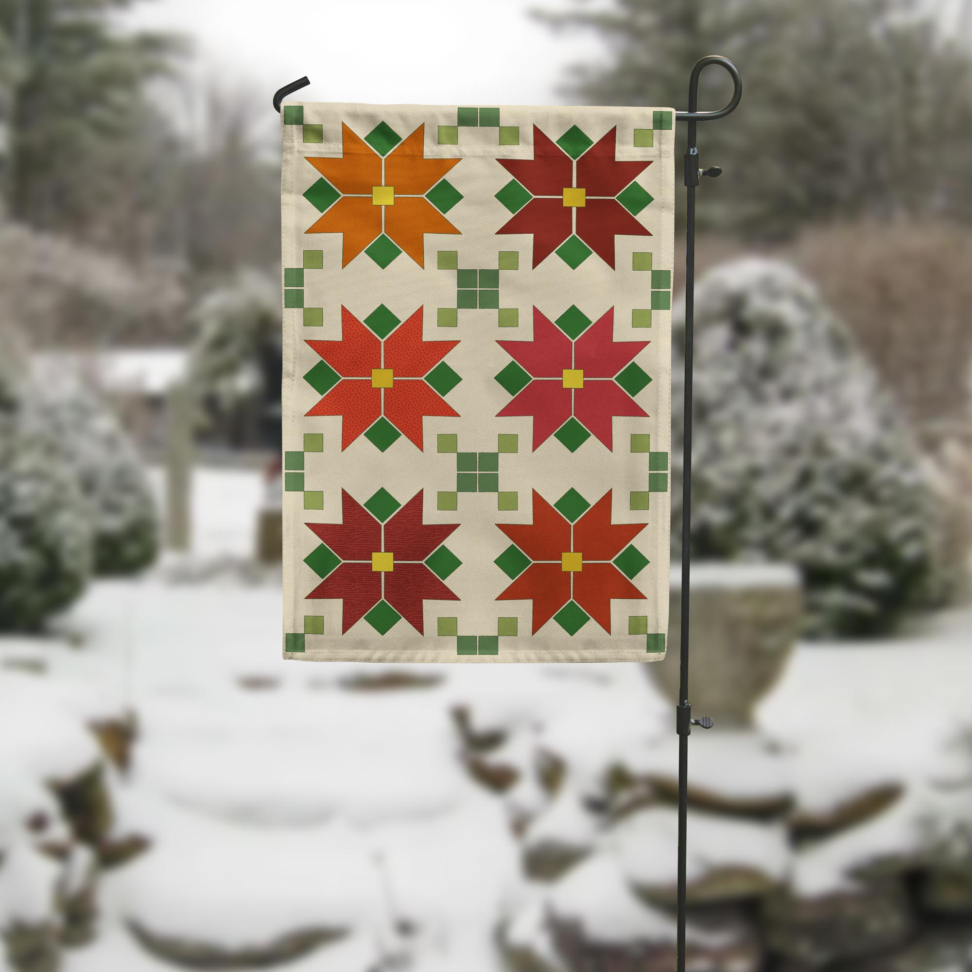 Decorative garden flag with red and green poinsettia pattern on a snowy background