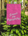 smash the patriarchy garden flag in a garden setting