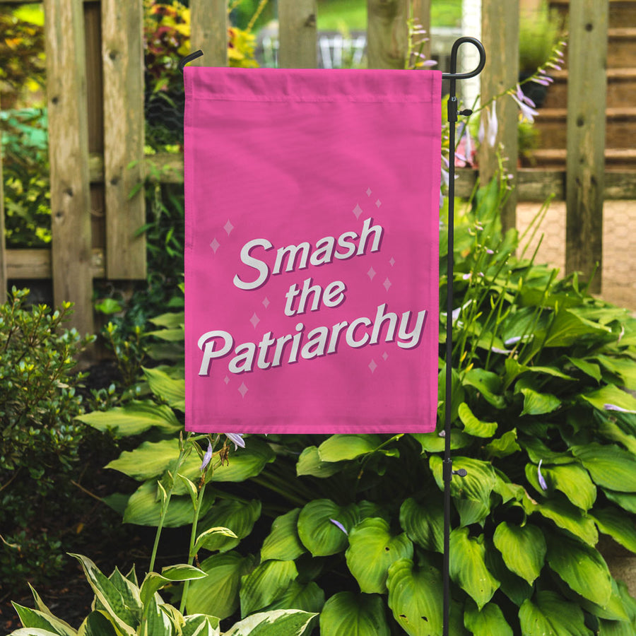 smash the patriarchy garden flag in a garden setting