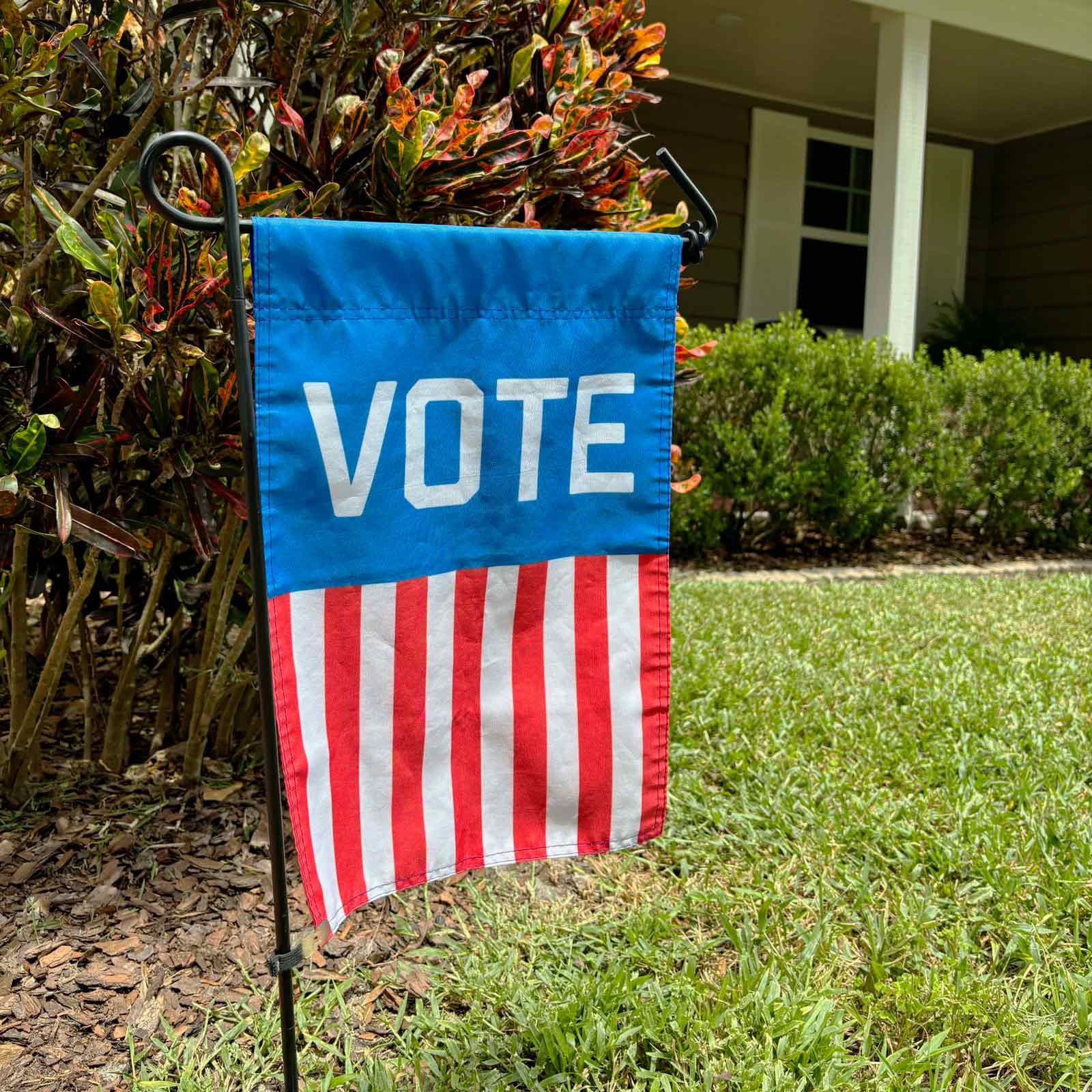 "VOTE" Garden Flag hanging in front of a house