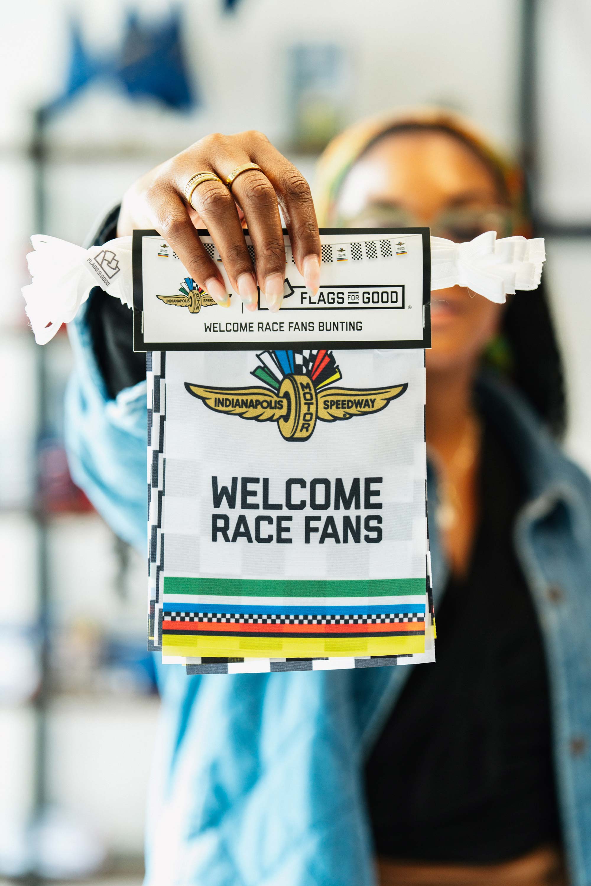 woman holding out the packaged welcome race fans IMS bunting