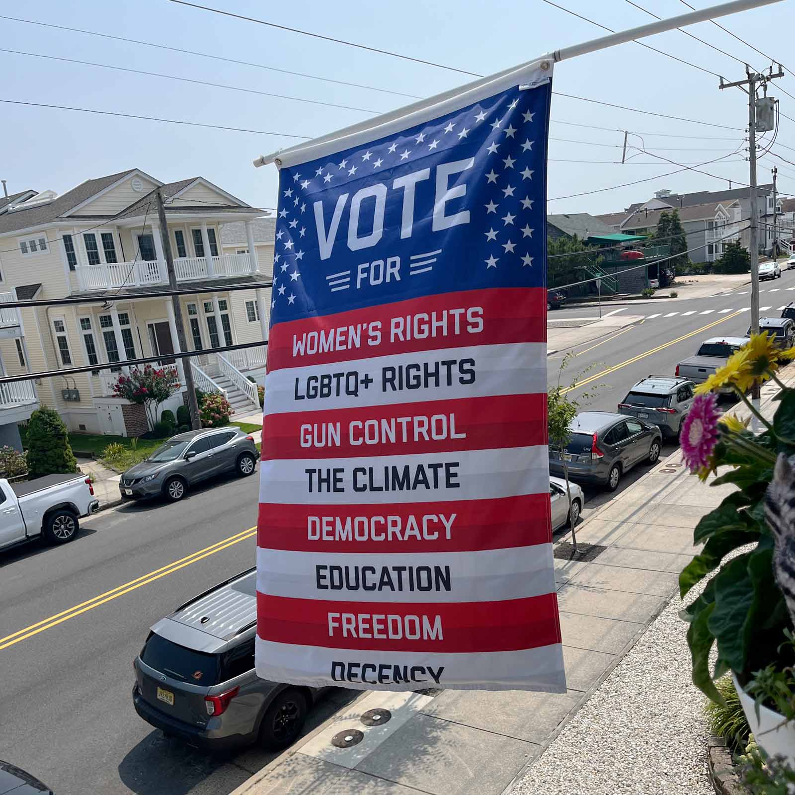 What You're Voting For flag hanging vertically from a balcony