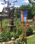 Customer photo of the "for all" flag in a large flower garden