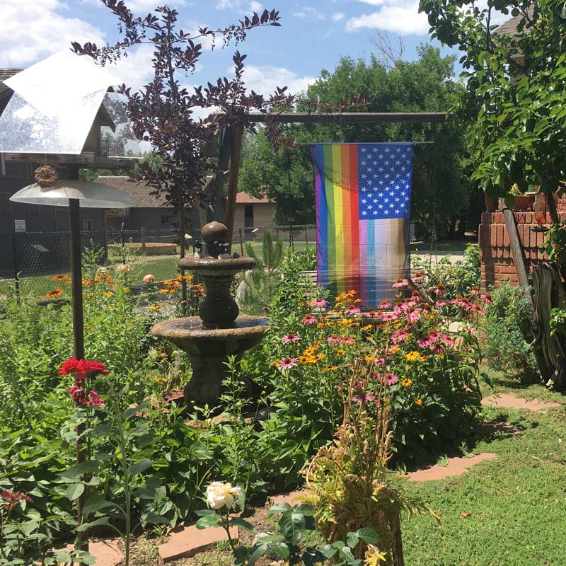 Customer photo of the "for all" flag in a large flower garden