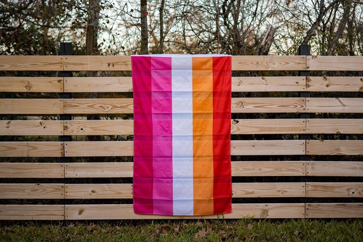 5 stripe Lesbian Pride Flag hanging on a fence